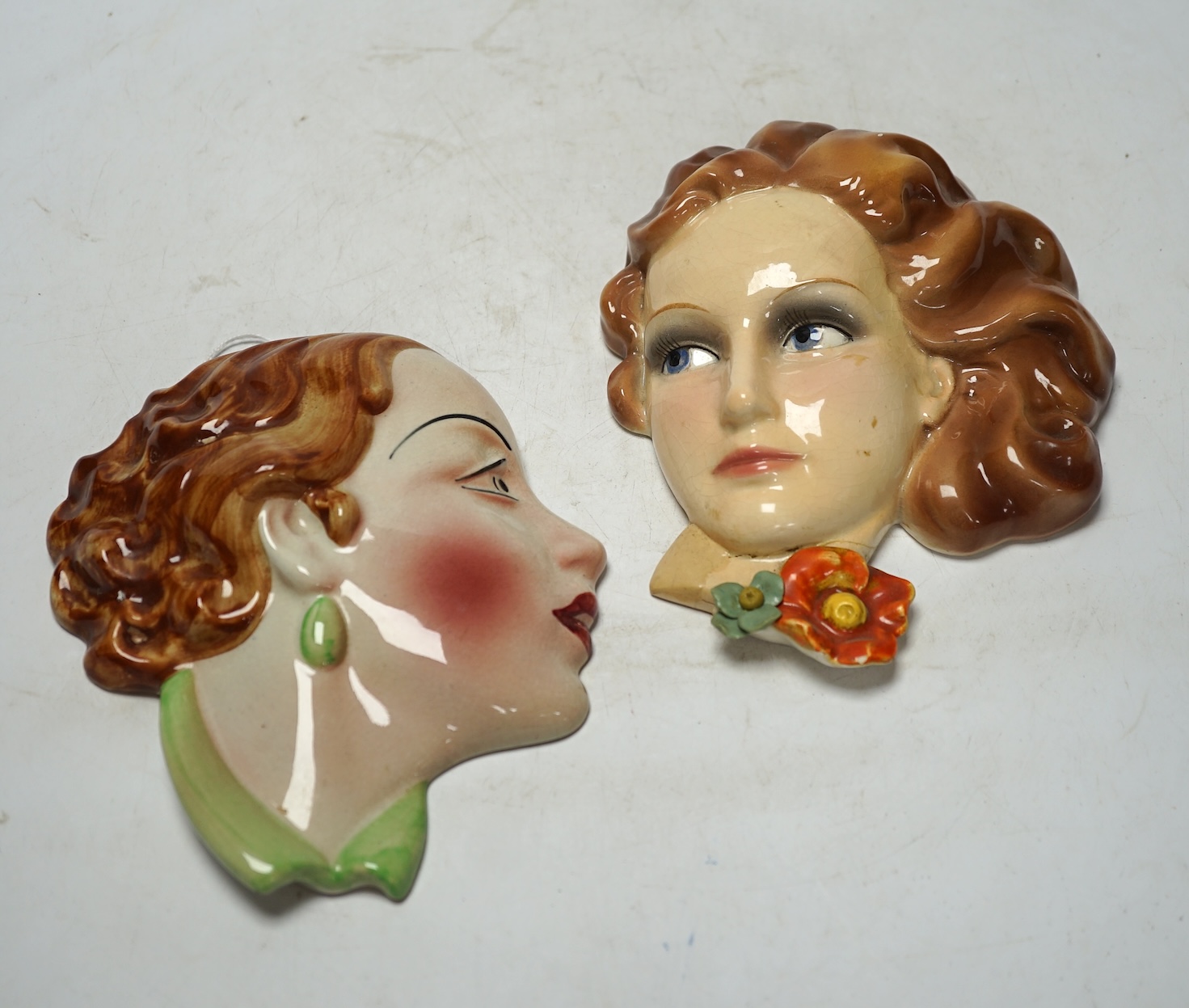 From the Studio of Fred Cuming. Two pottery wall masks including a Copes & Co. Art Deco example, largest 17cm high. Condition - Copes & Co. good, other poor